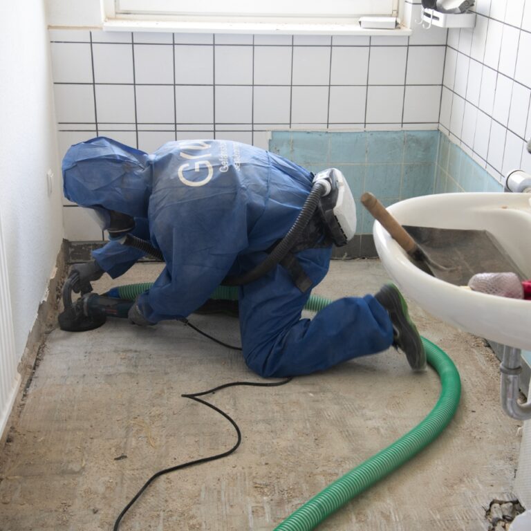 Ein Mann bearbeitet den Boden in einem Badezimmer