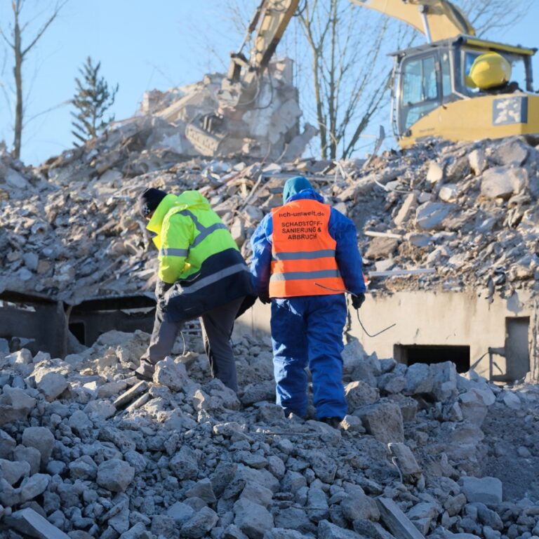 Zwei Männer stehen auf Abbruchstücken auf einer Baustelle